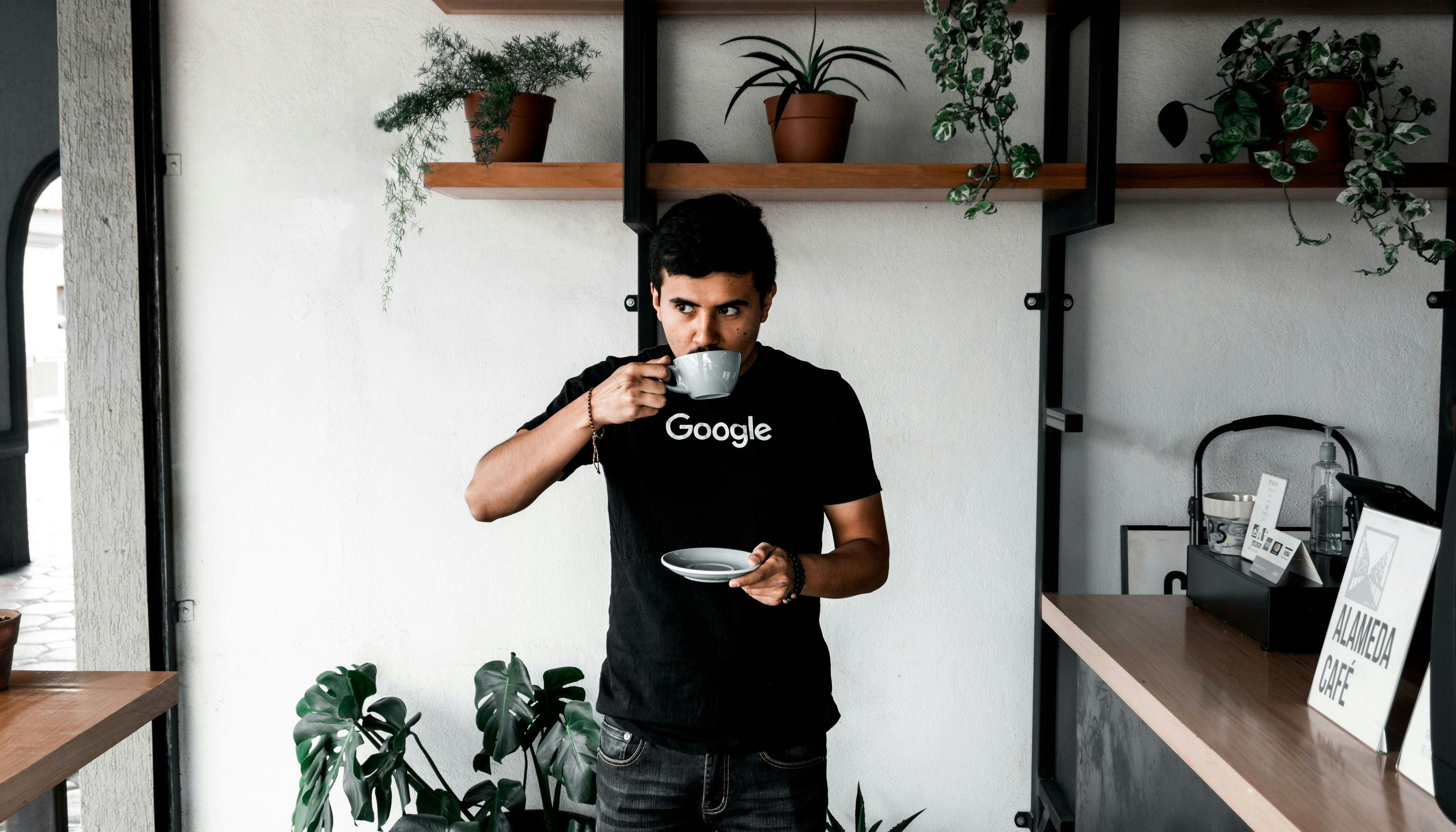 Man drinking coffee in a Google t-shirt